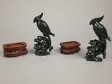 four pieces of carved figurines of birds sitting on top of a table