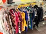 beaucoup de vêtements suspendus à une étagère dans un magasin
