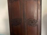 a large wooden armoire in the corner of a room
