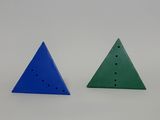 two triangulars with holes in each of them on a white surface