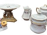 three different types of porcelain teapots and a cake plate