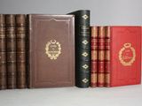 several old books are lined up on a white surface