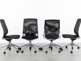 three black office chairs sitting on top of each other in front of a white wall