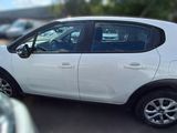 a small white car parked in a parking lot