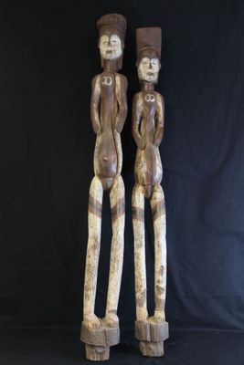 two wooden statues of two people standing next to each other