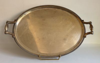 un plat ancien en argent, muni de poignées, sur un fond blanc