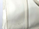 a white handbag sitting on top of a suitcase