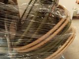 a basket of bananas wrapped in plastic sitting on top of a table