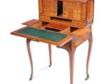 an old wooden desk with a green top and drawers
