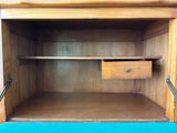 a wooden cabinet with a drawer and a drawer underneath it