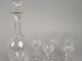 four wine glasses and a decanter on the table