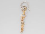 gros plan d'une paire de boucles d'oreilles sur une surface blanche