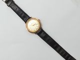 a close up of a watch on a white surface with a black strap