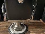 black and chrome barber chair on wooden floor in a barber shop