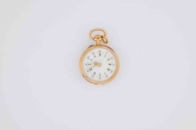 a close up of a pocket watch on a white surface