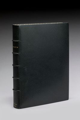 un livre relié en cuir noir avec des bordures dorées