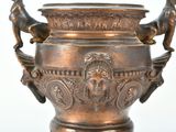a bronze vase with a statue of a man and a dog on it