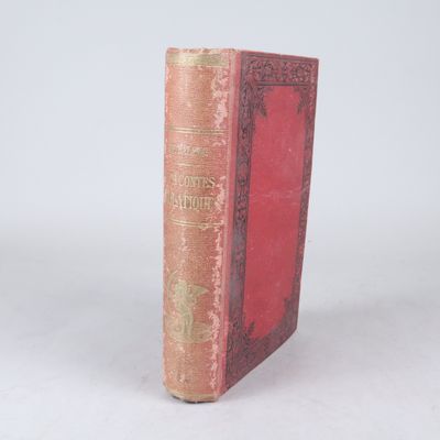 un vieux livre à la couverture rouge posé sur une surface blanche