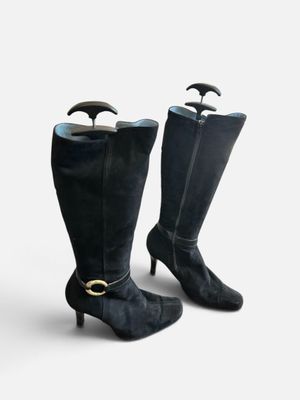une paire de bottes en cuir noir avec une boucle dorée au talon