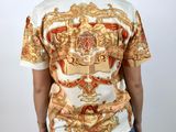 the back of a woman wearing a white shirt with a gold and red design