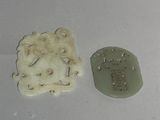 two pieces of white and green clay on a white surface