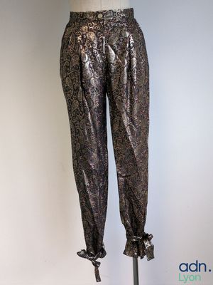 the mannequin is standing on a metal stand with a black top and silver pants