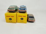 three toy cars are sitting on top of boxes on a white surface