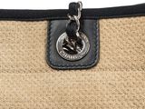 a close up of a black and tan bag with a metal clasp