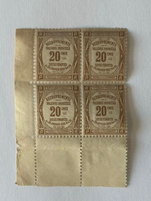 quatre vieux timbres sont posés sur un morceau de papier