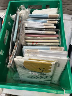 a green box full of books and a pair of scissors