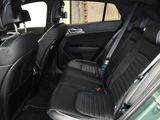 the back seats of a green car with black leather trims