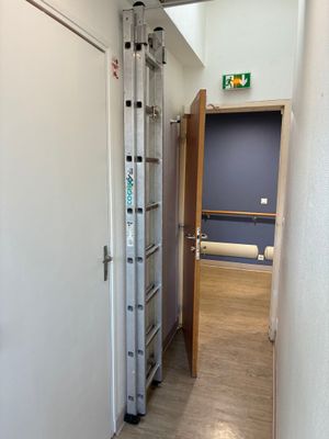 une échelle appuyée contre un mur dans un couloir