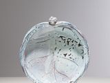 a white plate with a bird on it sitting on a table