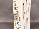 a white vase with a colorful design on it