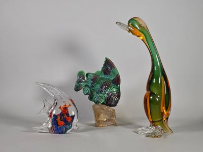 trois figurines en verre de formes et de tailles différentes posées sur une table
