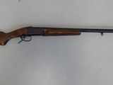 un fusil posé sur une surface blanche