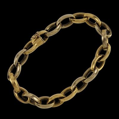 un bracelet à maillons en or avec un fermoir, sur fond noir