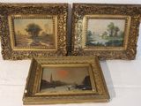 three framed paintings on a white table with a white table cloth