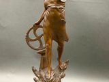 statue of a woman holding a tennis racquet on a wooden base