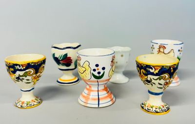 five different types of painted egg cups on a table