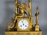 une horloge en or surmontée d'un ange