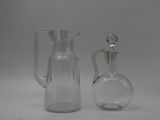 two glass jugs sitting next to each other on a table