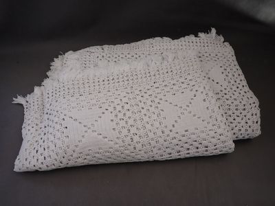a white crocheted cloth on a black table