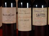 three bottles of red wine are lined up on a table