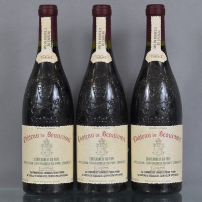 trois bouteilles de vin sont posées sur une table en verre