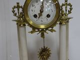 a white and gold clock sitting on top of a table