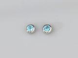 une paire de boucles d'oreilles en topaze bleue sur fond blanc