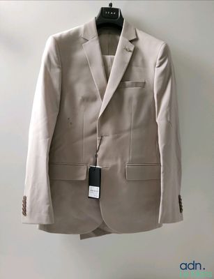 a suit hanging on a hanger on a wall