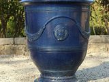 a blue planter with a small tree in it