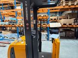 the fork lift truck is parked in the warehouse with pallets in the background